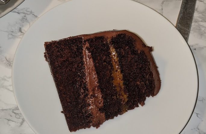A layered cake with a chocolate butter cream, caramel and chocolate ganache